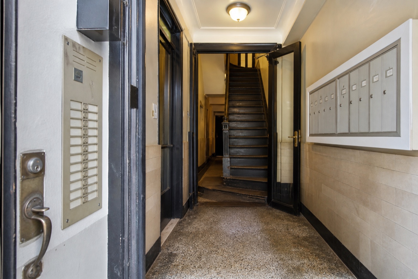 NYC apartment building entry with lock, intercom, mailboxes and stairs